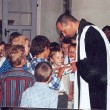 Schuleingang 2003 - Pfarrer Führer zeigt den Kindern etwas spannendes!